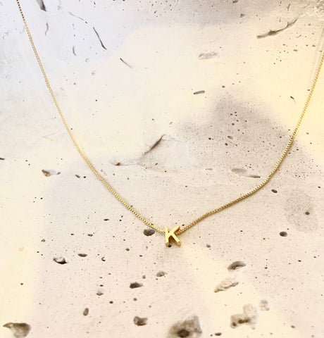 Mujer luciendo choker con inicial dorada - Cadena personalizable cuello delicada