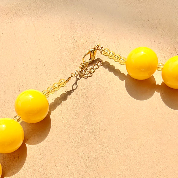 Detalle cierre ajustable maxi collar esferas amarillas tipo ábaco MariaBolo, diseño colorido para looks de verano y playa