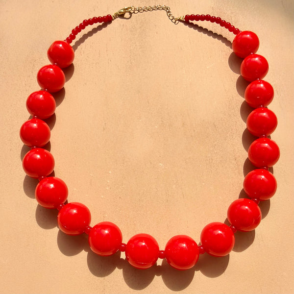 Detalle collar pepas medianas rojo ábaco MariaBolo, diseño statement equilibrado boho chic ideal para looks de día y noche