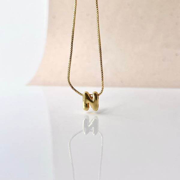 Dije letra cupidito de 2 cm en rodio con baño dorado