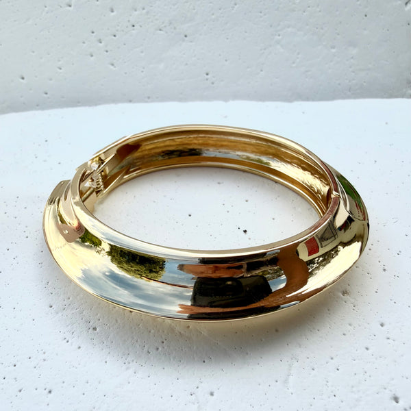 Brazalete dorado rígido asimétrico triangular punta rodio MariaBolo en muñeca, aro con apertura delicado geométrico talla única capa brillo hipoalergénico regalo premium Colombia