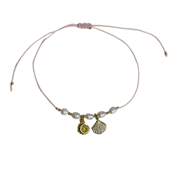 Pulsera de perlas de agua y dijes en rodio forma de concha en hilo ajustable