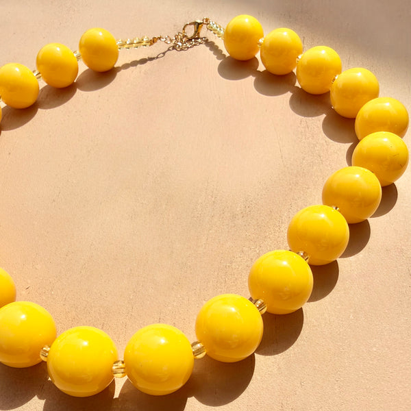 Detalle collar pepas medianas amarillo MariaBolo, diseño statement equilibrado boho chic ideal para looks de día y oficina