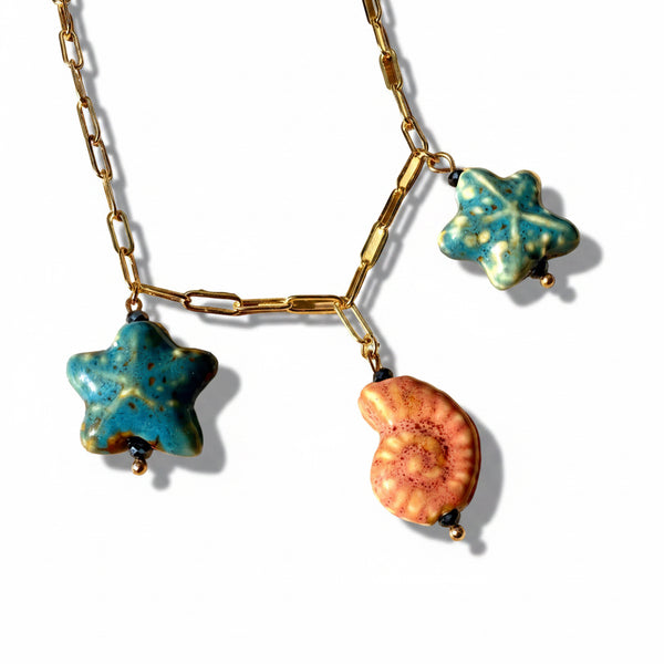 Detalle dijes marinos cerámica coral melocotón en cadena dorada óvalos collar statement MariaBolo