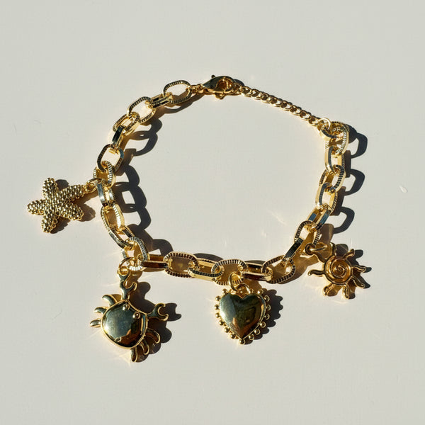 Pulsera eslabones dorados dijes marinos MariaBolo en uso, tema marino playero verano regalo único mujer Colombia