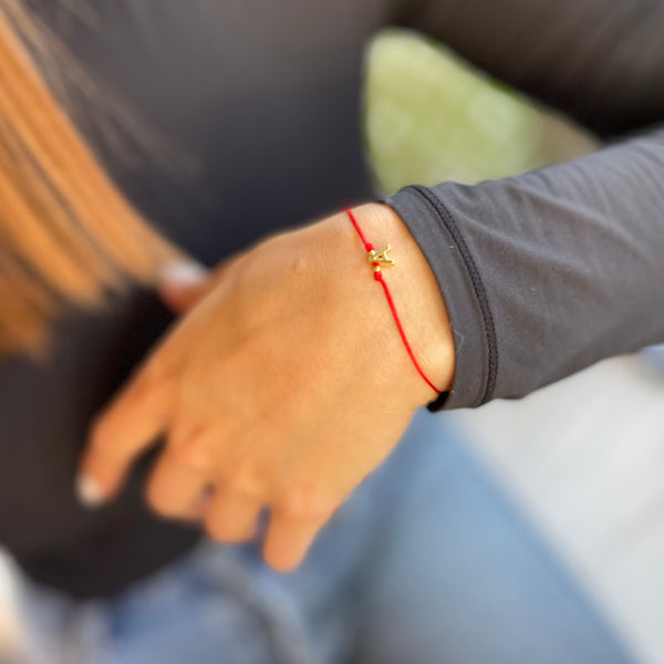 Detalle pulsera hilo rojo con inicial - Letra dorada covergold protección
