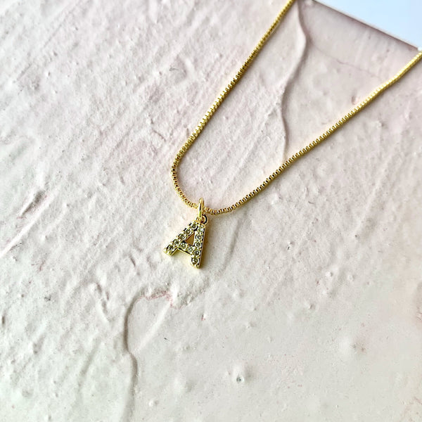  Detalle de collar inicial letra A en baño de oro 18k con cierre ajustable